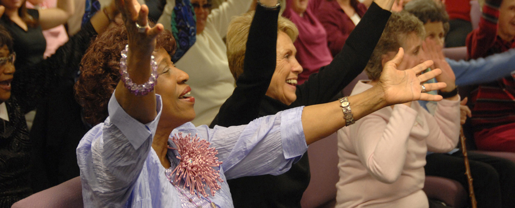 Older Adults reaching out their arms at IOG event
